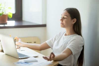 Concentrated female meditating in mudra position