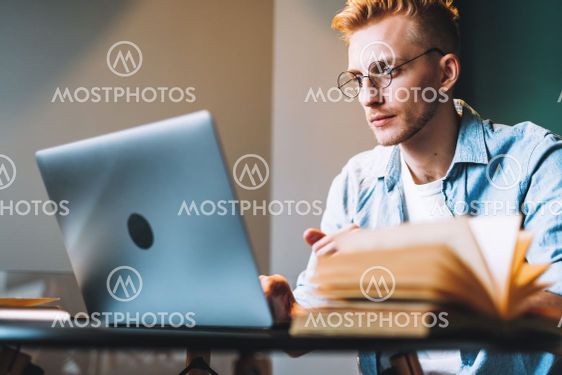 Caucasian man college student in glasses studying with...
