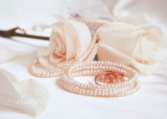 Wedding rings and white roses