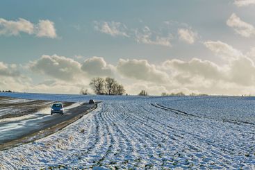 Farm, field and countryside with snow, blue sky and...