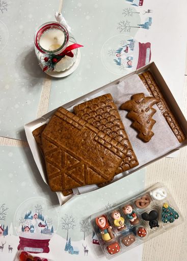 Festive gingerbread house preparation with decorations...