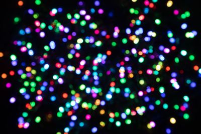 Multicoloured light confetti on a black background....