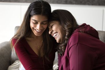 Women sitting close together, joking, laughing enjoy talk
