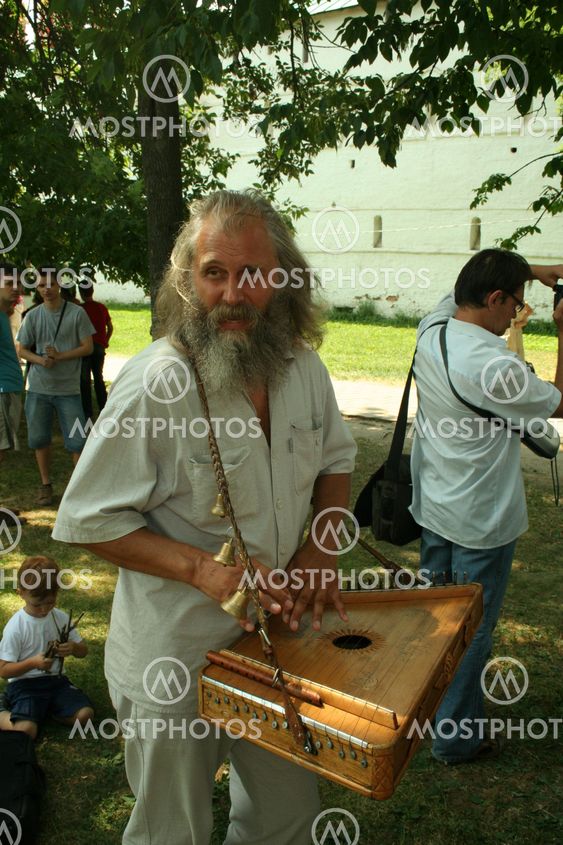 An elderly man playing the harp