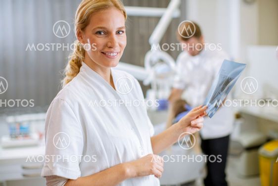 Female dentist examining the x-ray for the treatment
