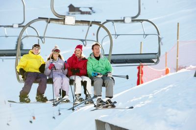 Teenage Family Getting Off chair Lift On Ski Holiday In...