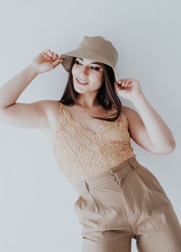 brunette in a hat summer vacation poses against a white...
