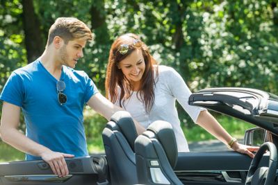 Couple Looking At Their Newly Purchased Car