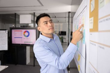 Focused young Asian business project leader man working...