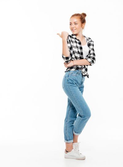 Full length image of cheerful ginger woman in shirt