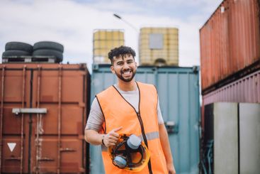 Portrait of happy young construction worker with hardhat...