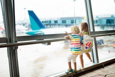 Kids travel and fly. Child at airplane in airport
