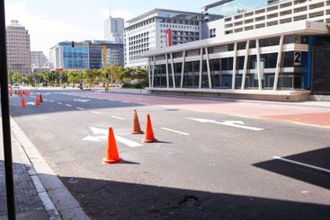 City, street and traffic cone on road to block for...