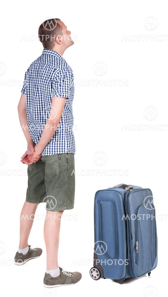 Back view of young man traveling with suitcas.