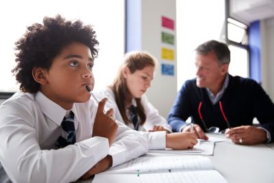 Concentrating Male High School Student Wearing Uniform...