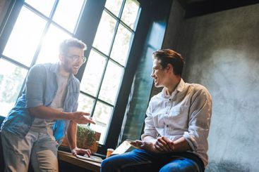Two business colleagues sitting at a table, having a...