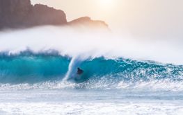 young adult surfing on a big wave in the ocean