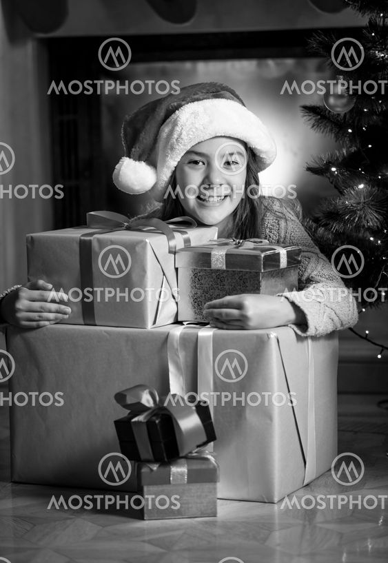 portrait of cute smiling girl posing with Christmas gift...