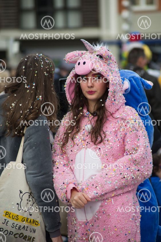 girl wearing a unicorn costume in the street during the...