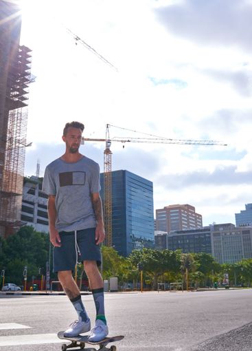 Man, skateboard and outdoor on crosswalk in city,...