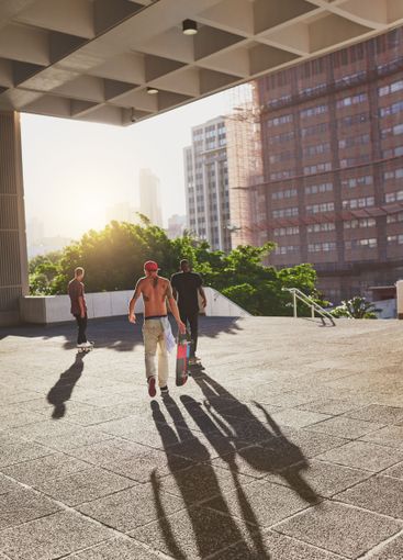 Training, city and group with skateboard, sports and...