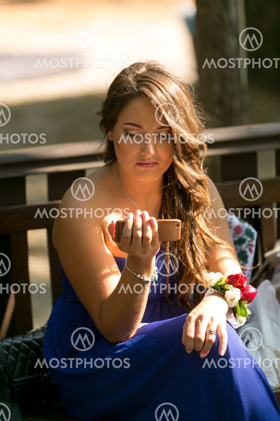 brunette bridesmaid using smartphone and browsing internet