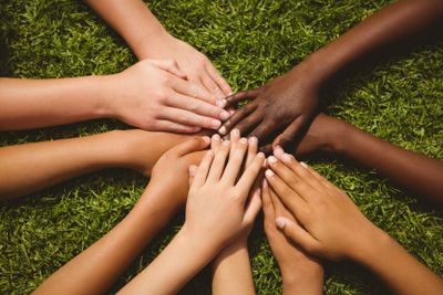 Children keeping hands together over grass