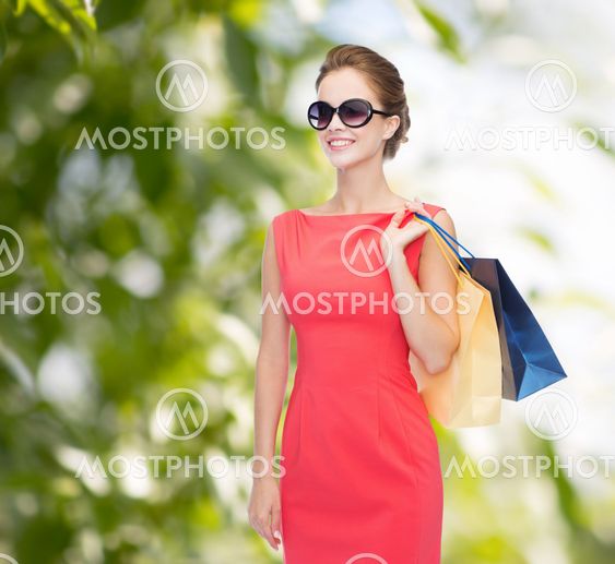 smiling elegant woman in dress with shopping bags