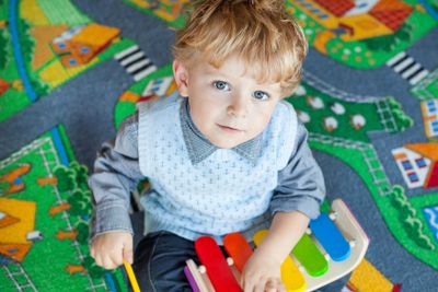 Little toddler boy playing with wooden music toy