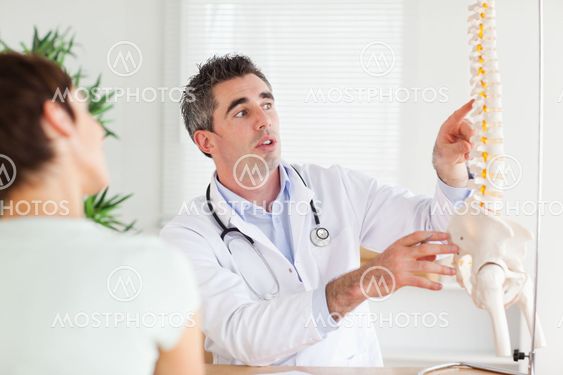 Doctor showing a woman a part of a spine