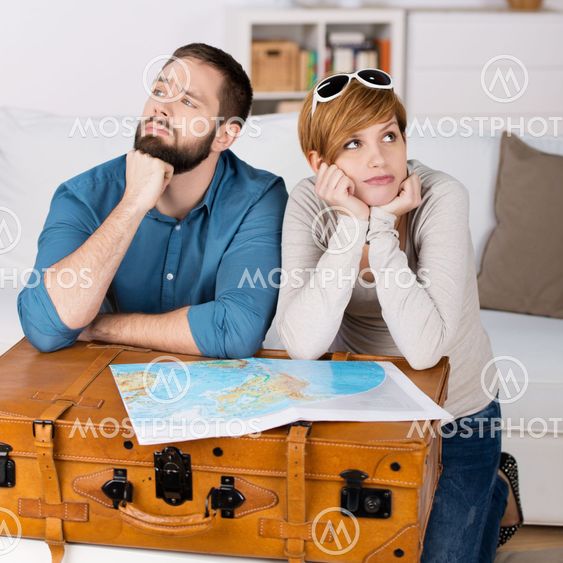 Couple With Map Leaning On Suitcase In House