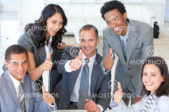 Happy businessteam with thumbs up in office