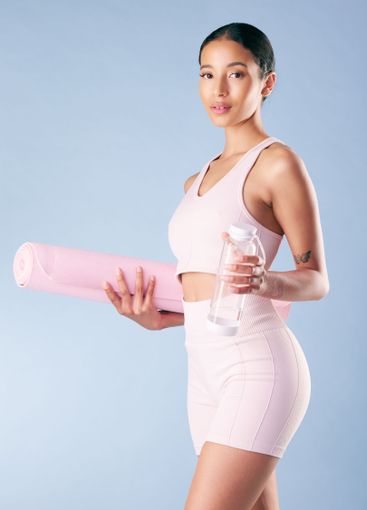 Fitness, woman and yoga mat with water in studio for...