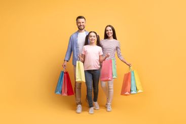 Family enjoys shopping together with colorful bags in a...
