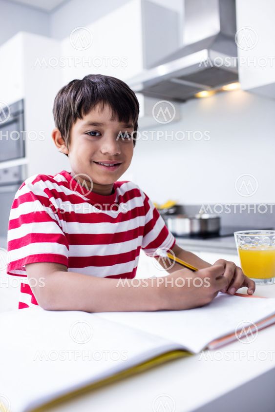 Boy doing homework in kitchen