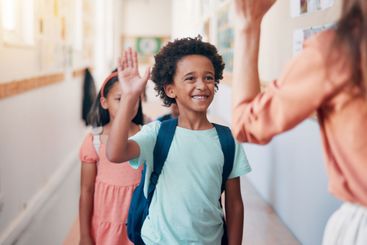 Teacher, children and high five at school, happy and...