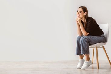 Friendly young Caucasian woman in casual wear sitting on...