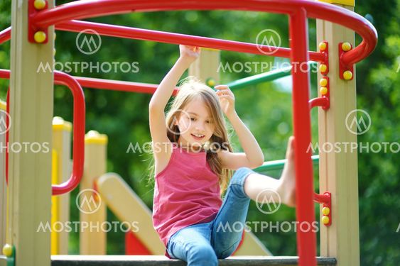 Cute little girl having fun on a playground outdoors