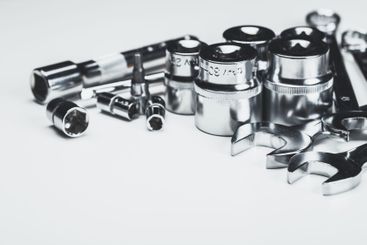 Assorted metal tools arranged on a white background for...