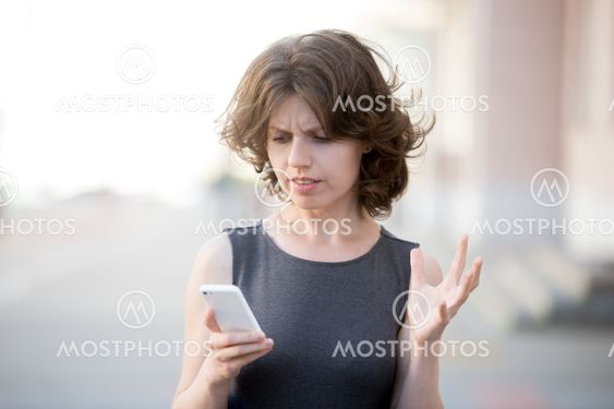 Young business woman irritated with her phone