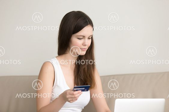 Young lady shopping online at home, paying by credit card