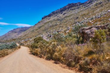 Mountain, dirt road or nature with blue sky for...