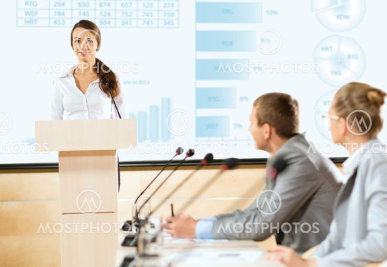 Business woman speaks into a microphone