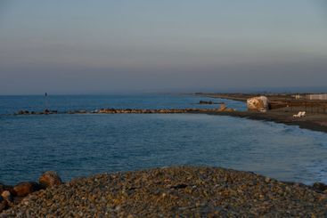 Serene coastal landscape at dusk with gentle waves...