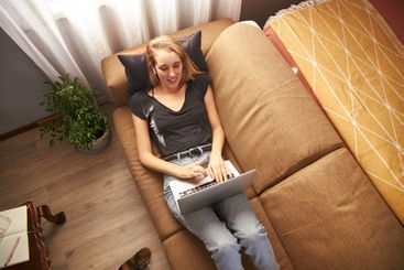 Young female working from home on sofa