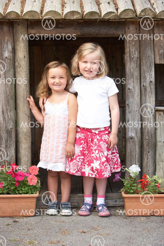 Two Young Girls Playing in Wooden House