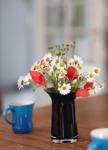 Bouquet, flowers and vase on table with tea for...