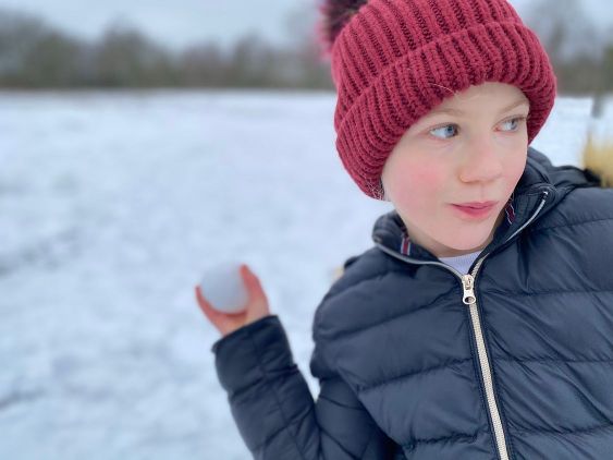 En flicka som kastar snöboll