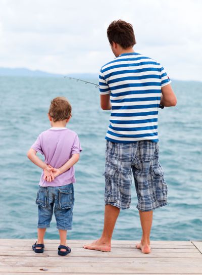 Father and son fishing from pier