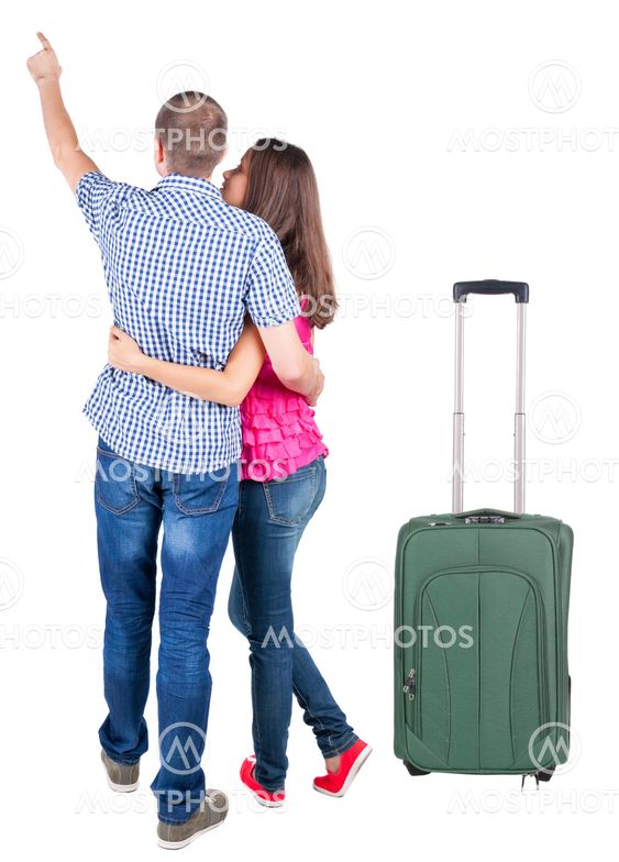 young couple traveling with suitcas and pointing at wal...